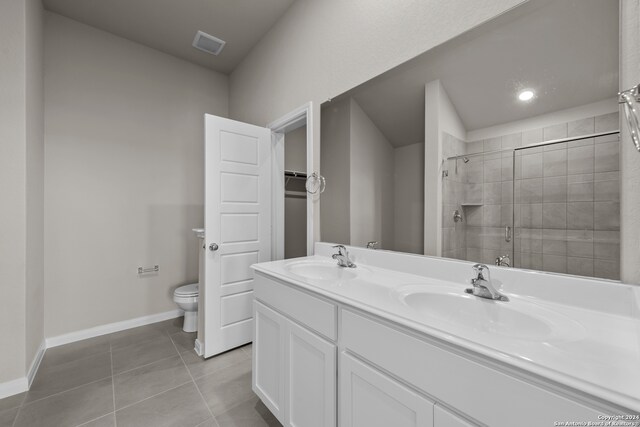 bathroom featuring toilet, vanity, tile patterned floors, and an enclosed shower