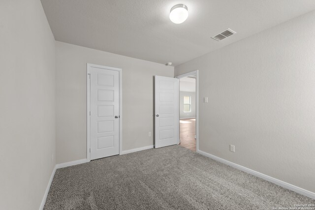 unfurnished bedroom with a closet and carpet