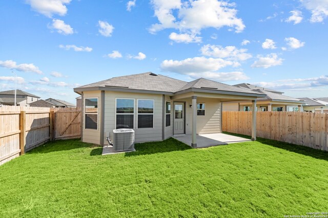 back of house with a lawn, cooling unit, and a patio area