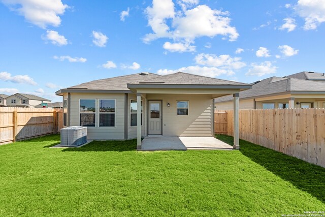 back of property with a lawn, central AC, and a patio