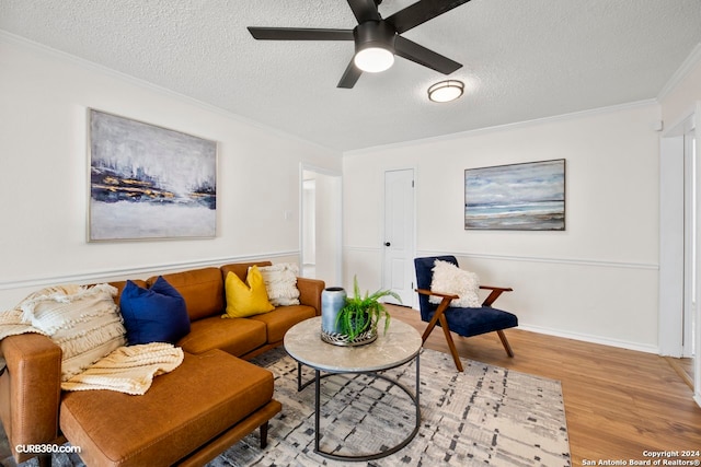 living room with hardwood / wood-style floors, ornamental molding, ceiling fan, and a textured ceiling