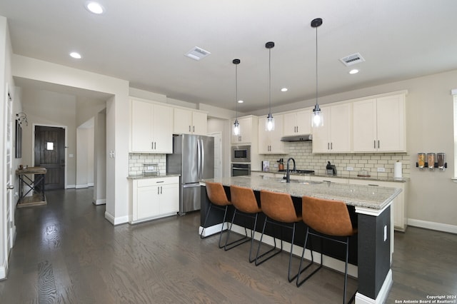 kitchen with white cabinets, stainless steel appliances, hanging light fixtures, and dark wood-type flooring