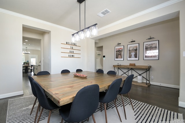 dining room featuring a chandelier, crown molding, and dark wood-type flooring