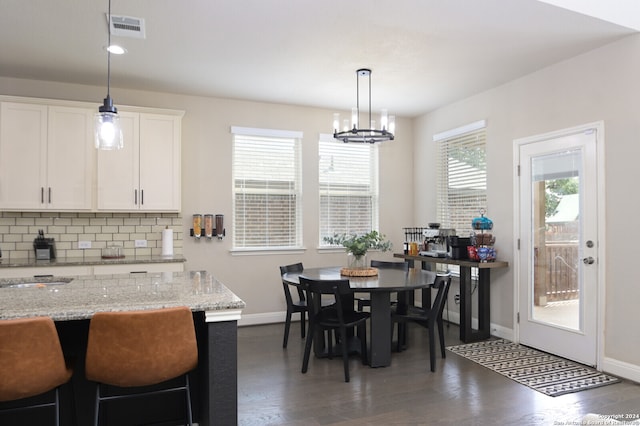 dining area with a notable chandelier, dark hardwood / wood-style floors, and sink