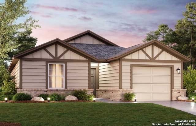 view of front of home with a yard and a garage