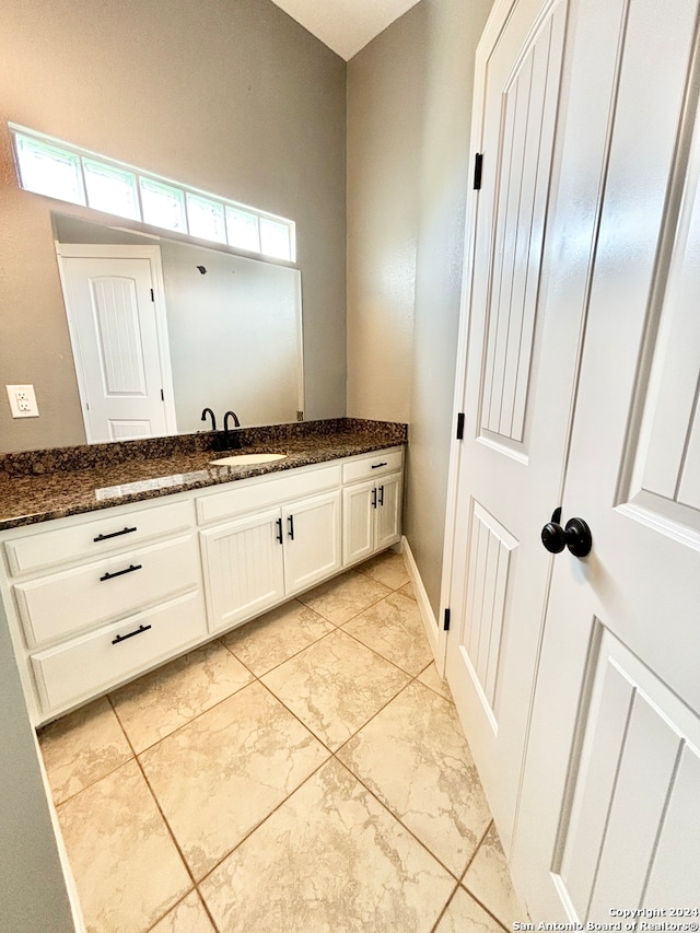 bathroom with tile patterned floors, vanity, and a healthy amount of sunlight