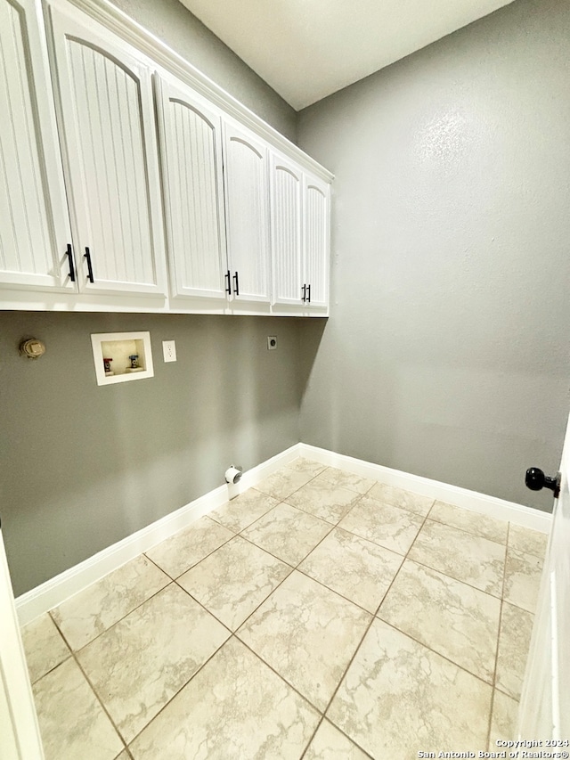 washroom featuring cabinets, hookup for a washing machine, light tile patterned floors, and electric dryer hookup