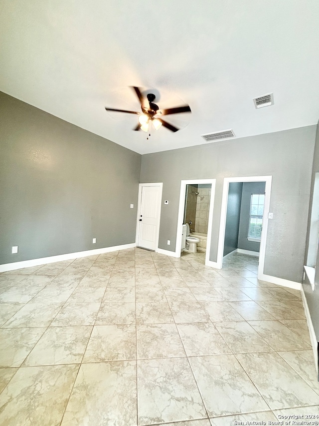 tiled spare room featuring ceiling fan