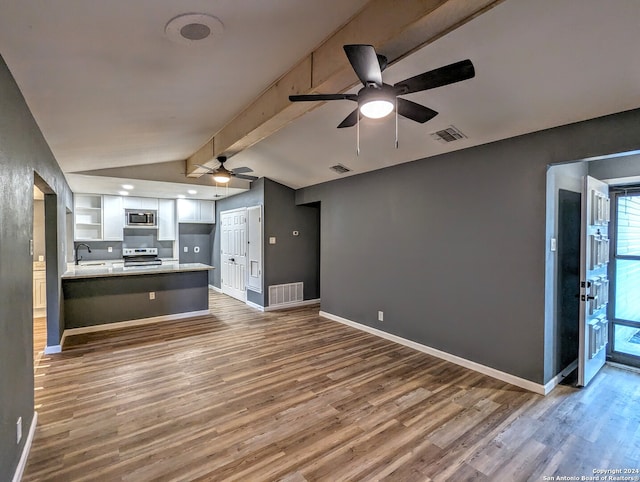 unfurnished living room featuring ceiling fan, vaulted ceiling with beams, hardwood / wood-style floors, and sink