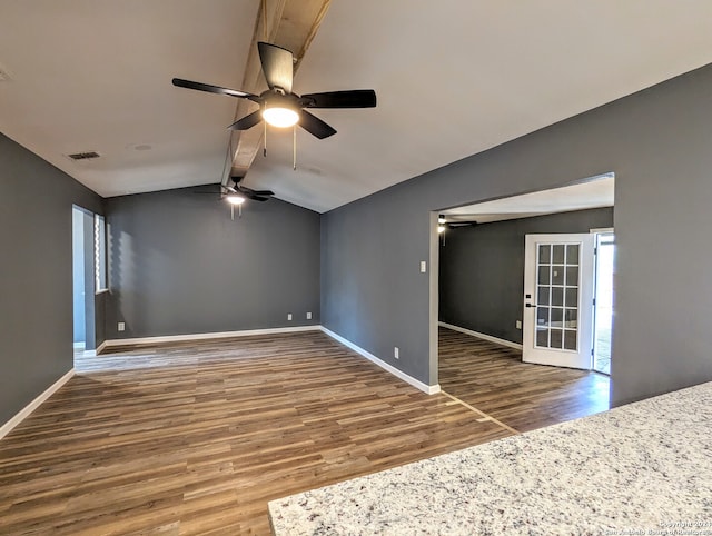 empty room with ceiling fan, vaulted ceiling with beams, and hardwood / wood-style flooring