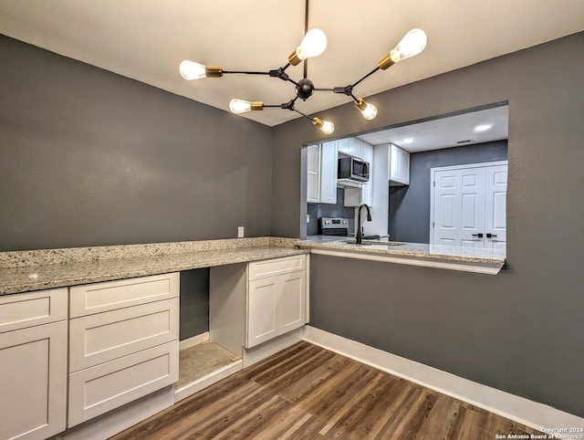 kitchen featuring stainless steel microwave, dark hardwood / wood-style flooring, white cabinets, light stone counters, and sink