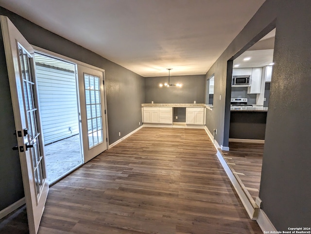 interior space featuring a wealth of natural light, an inviting chandelier, and dark hardwood / wood-style floors