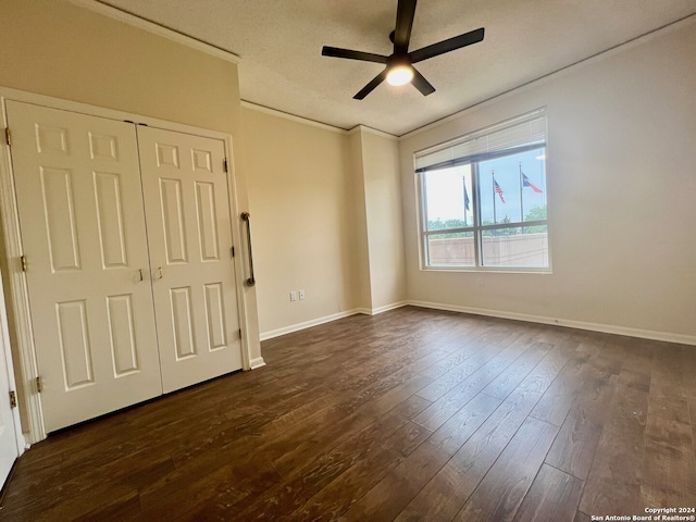 spare room with a textured ceiling, ornamental molding, ceiling fan, and dark hardwood / wood-style flooring