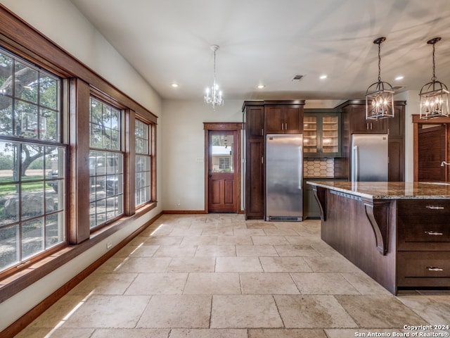 kitchen featuring stainless steel fridge, tasteful backsplash, light tile floors, and pendant lighting