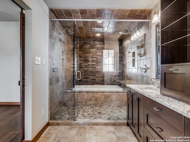 bathroom with vanity, tile walls, tile floors, and a shower with door