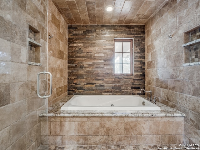 bathroom featuring built in features and tiled bath