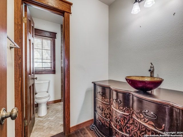 bathroom featuring vanity, toilet, and hardwood / wood-style flooring