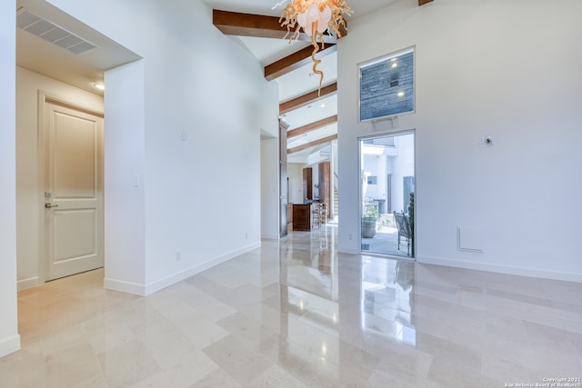 spare room with beam ceiling, high vaulted ceiling, and light tile flooring