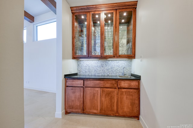 kitchen featuring beamed ceiling, tasteful backsplash, and light tile floors