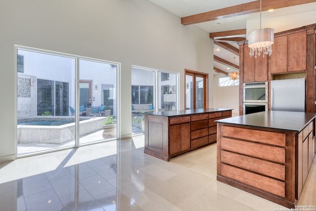 kitchen featuring hanging light fixtures, a kitchen island, stainless steel appliances, a notable chandelier, and light tile floors