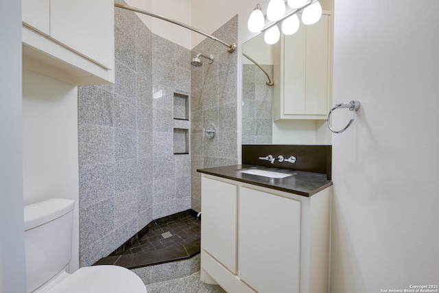 bathroom featuring tiled shower, vanity, and toilet