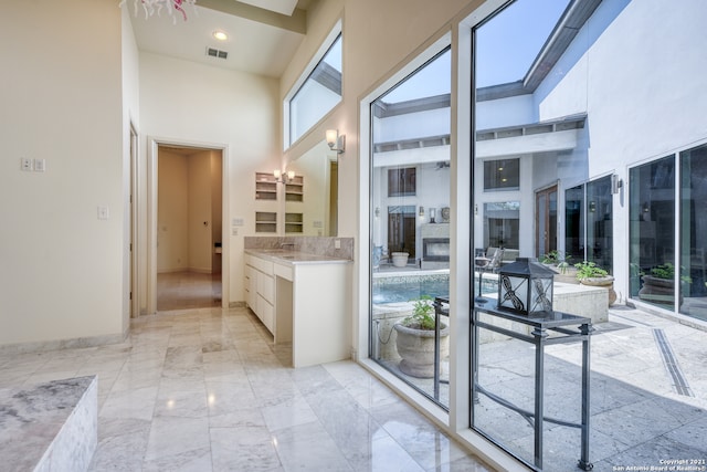 interior space featuring a high ceiling, tile flooring, and vanity