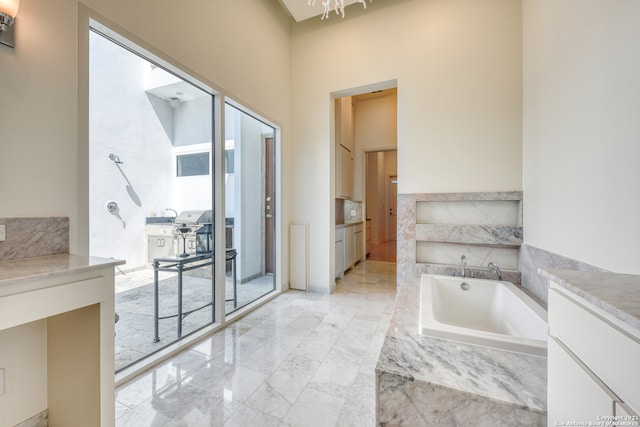 bathroom with a healthy amount of sunlight, tiled tub, and tile floors