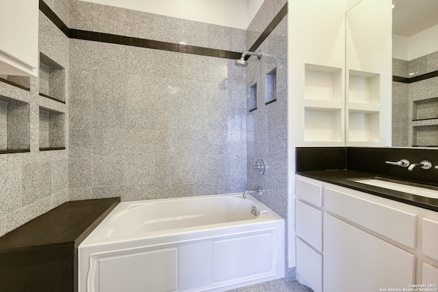 bathroom with tiled shower / bath and vanity