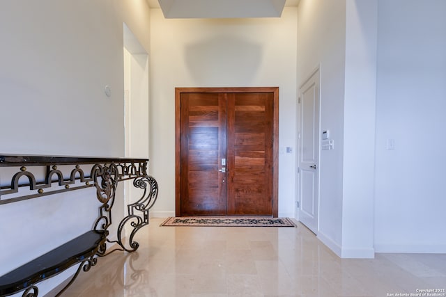 foyer entrance with tile floors and a high ceiling