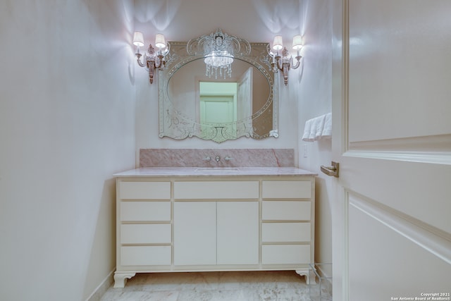 bathroom featuring a notable chandelier, tile flooring, and vanity