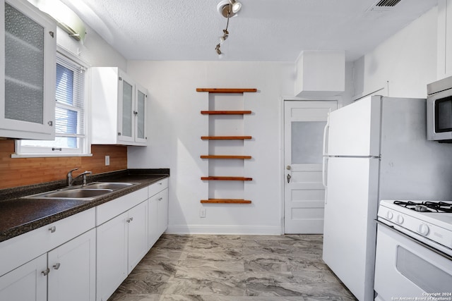 kitchen with white cabinetry, sink, track lighting, and light tile flooring