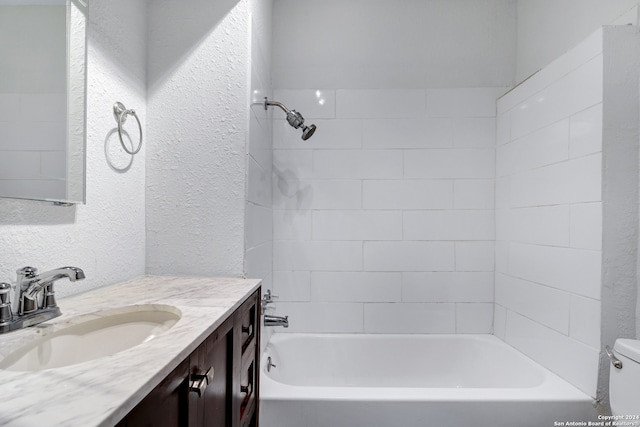 full bathroom featuring tiled shower / bath combo, toilet, and vanity with extensive cabinet space