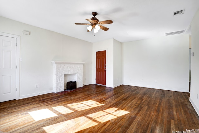 unfurnished living room with a stone fireplace, hardwood / wood-style flooring, and ceiling fan