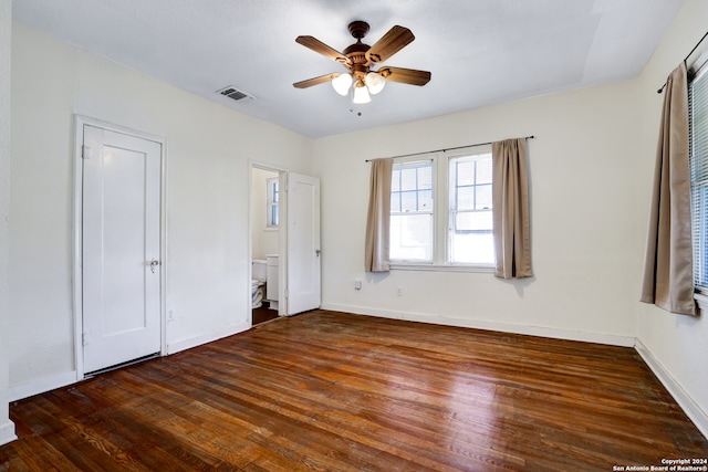 unfurnished bedroom featuring dark hardwood / wood-style flooring, ensuite bath, and ceiling fan