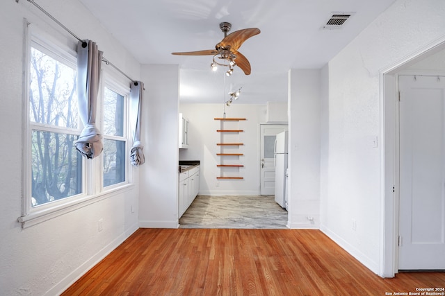 kitchen with white cabinetry, light wood-type flooring, white refrigerator, and ceiling fan