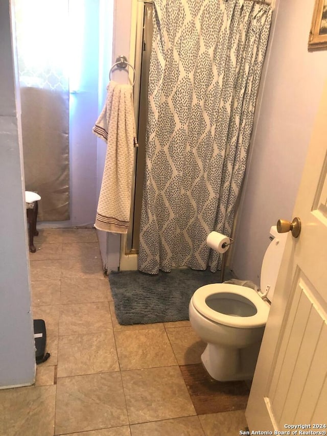 bathroom featuring tile floors and toilet