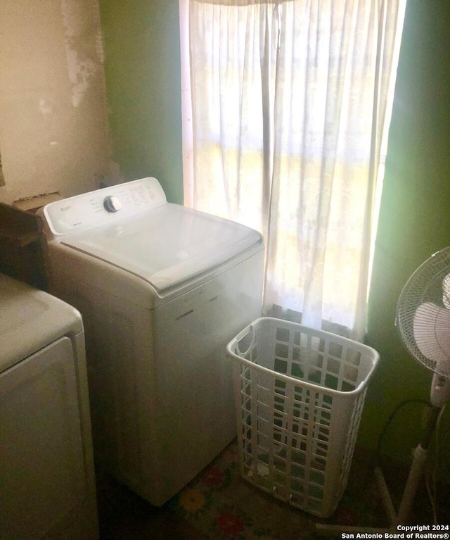 clothes washing area with separate washer and dryer and a wealth of natural light