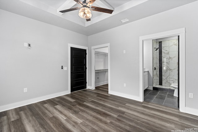 unfurnished bedroom featuring ensuite bathroom, ceiling fan, and dark hardwood / wood-style flooring