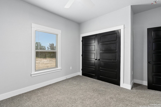 unfurnished bedroom with ceiling fan, a closet, and carpet flooring