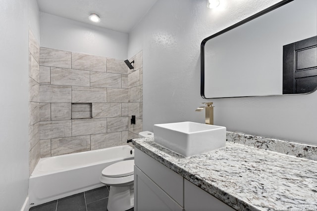 full bathroom with tiled shower / bath, tile flooring, toilet, and large vanity