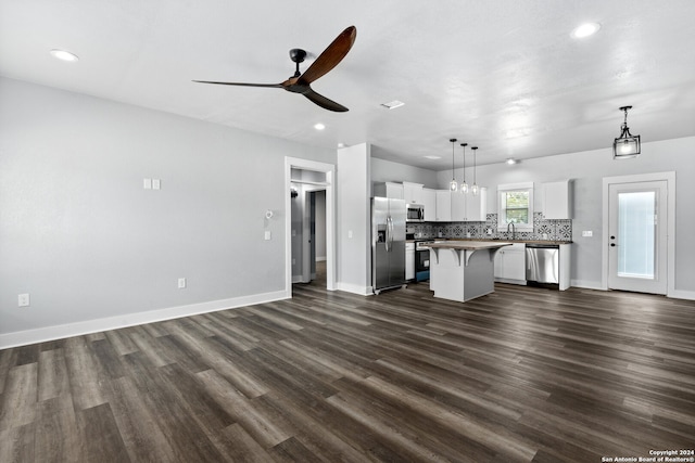 unfurnished living room featuring dark wood-type flooring and ceiling fan