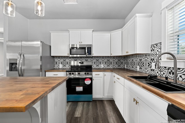 kitchen with decorative light fixtures, wood counters, dark hardwood / wood-style floors, tasteful backsplash, and appliances with stainless steel finishes