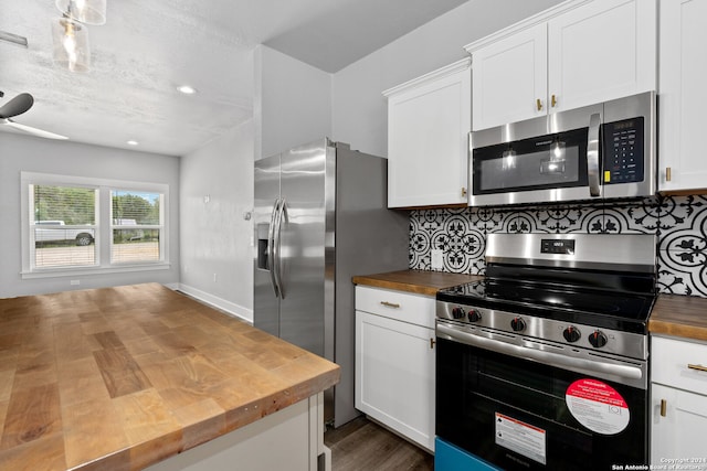 kitchen featuring tasteful backsplash, wooden counters, and appliances with stainless steel finishes