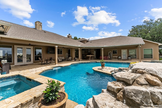 view of swimming pool with a jacuzzi, a patio, and french doors