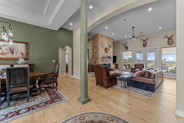 living room featuring brick wall, french doors, light wood-type flooring, and a fireplace