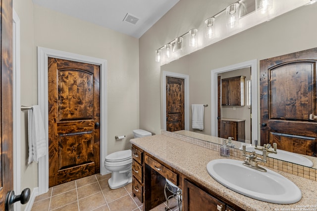 bathroom featuring tile floors, toilet, and oversized vanity