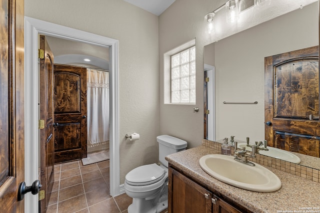 bathroom with tile floors, vanity, and toilet