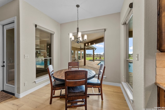 dining space with a notable chandelier and light hardwood / wood-style floors