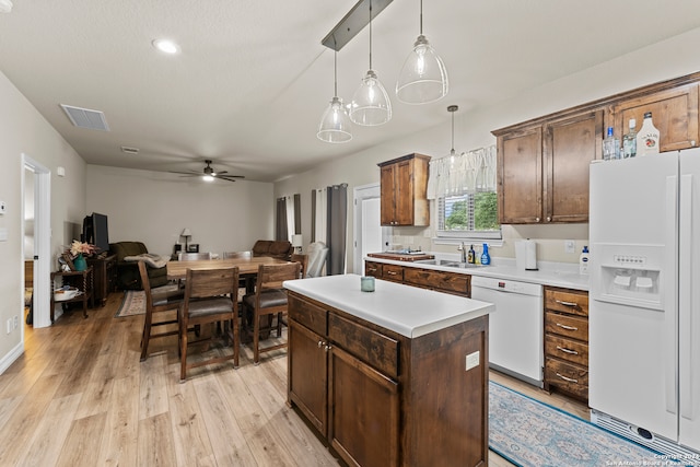 kitchen with decorative light fixtures, light hardwood / wood-style flooring, ceiling fan, a center island, and white appliances