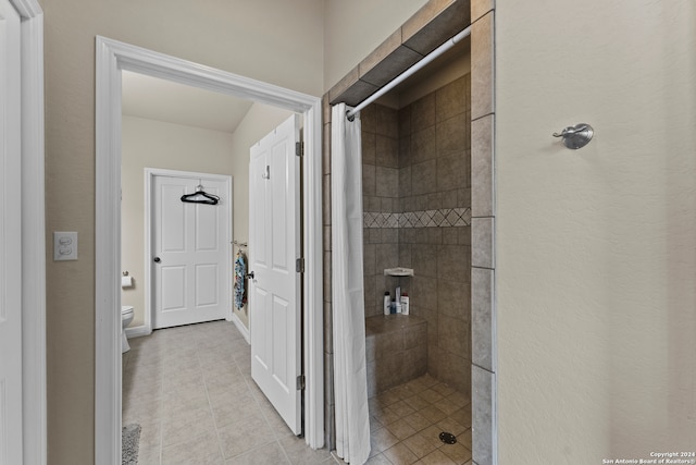 bathroom with a shower with curtain, toilet, and tile floors